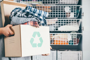 person holding box of clothes