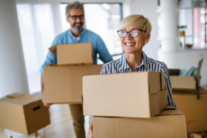 senior couple holding moving boxes