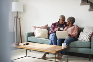 Senior Couple Sitting On Sofa At Home